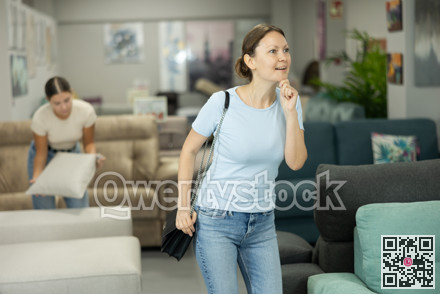 Womans eyes scan room furniture store, searching for perfect item to complete living space