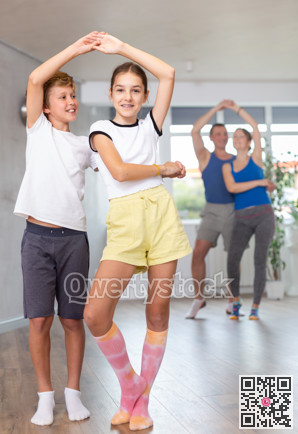 Active young children enjoying of partner dance in in dance studio during family class