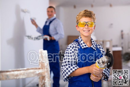 Portrait of positive young boy with angle grinder