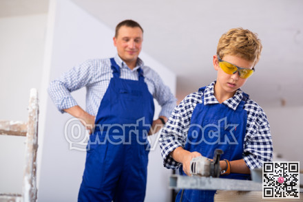 Boy renovating home with father, cutting profile