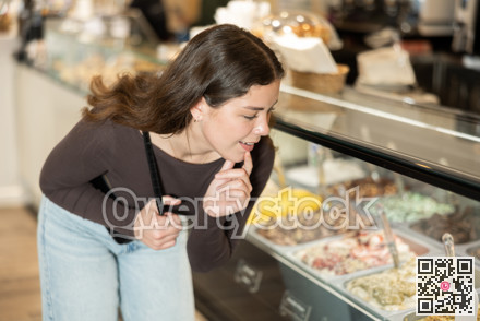 Girl at display case looks at selection of ice cream