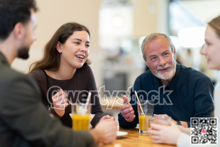Friendly family talking over dinner in modern cafe