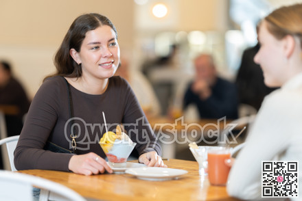 Young woman chatting with teenager in cafe