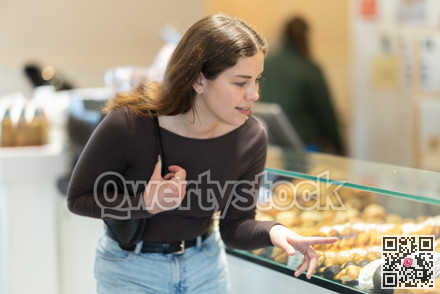Girl at display case looks at selection of pastries