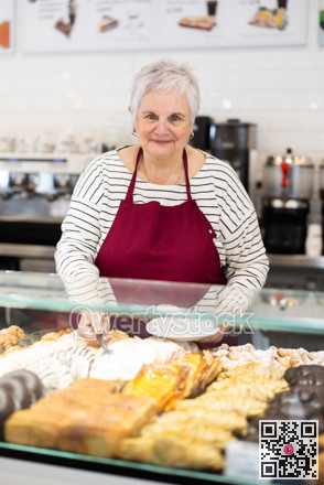 Senior woman salesperson works in cafeteria bakery shop