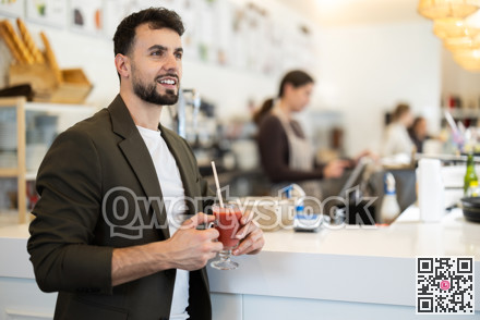 Food court guy visitor sits near table, drink juice in chain cafe shop