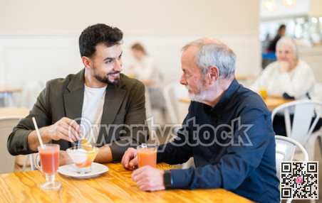 Senior man with guy meeting at cafe for cup of coffee