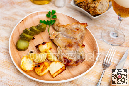 Tasty pork steak served with potatoes and pickles. Festive dinner