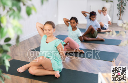 In sport studio with group of friends, girl perform cow head pose, Gomukhasana
