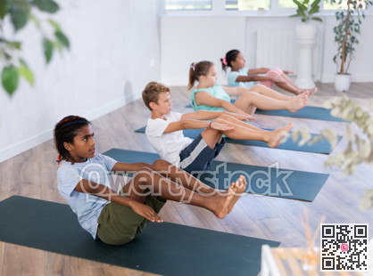 African boy perform boat asana - Paripurna navasana. Comprehensive hatha yoga class in mini group