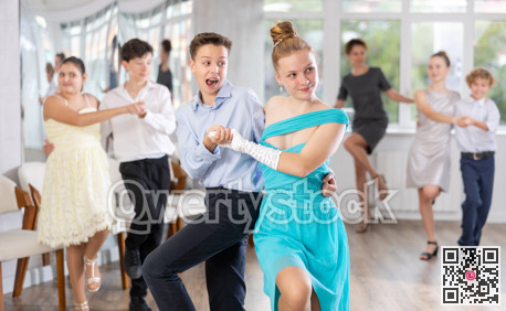 Group of festively dressed boys and girls dance twist dance