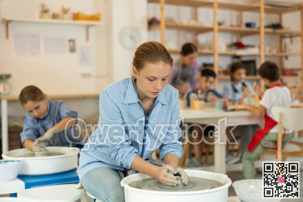 Teenage girl working at potter's wheel
