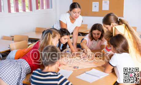 Teacher and pupils playing board game in school