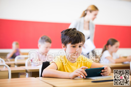 Girls and boys using gadgets during lesson