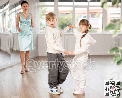 Boy and girl in sport wear train to dance contemporary vigorous rumba during classes.