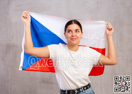 Calm cheerleader girl holds Czechia flag in her hands. Isolated on gray background