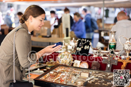 Young woman looking at retro ashtray at flea market