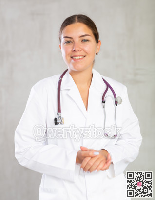 Happy young female doctor standing and smiling proud of her job