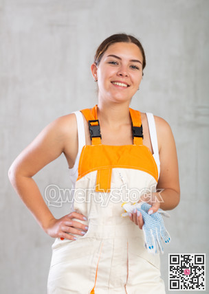 Portrait of happy emotional female builder or mechanic in overalls