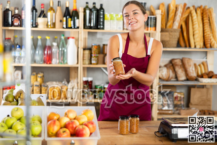 Young female seller offering lentils in grocery store