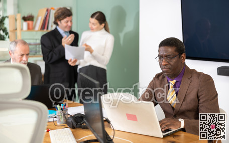 African man sitting at desk is working on laptop computer. Working day in office