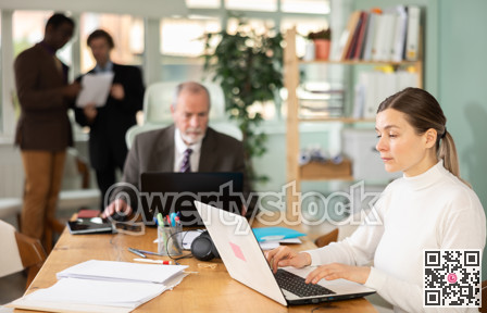 Businesswoman works in company office along with other office workers