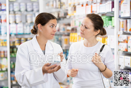 Pharmacist advises customer in pharmacy, offers medicine for body care