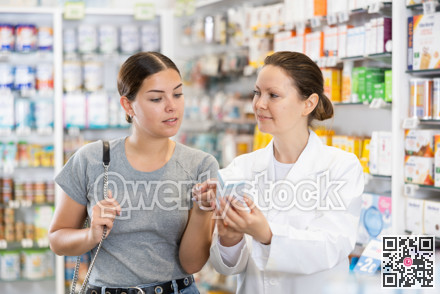 Female pharmacist advises a girl who came to the pharmacy to buy therapeutic cosmetics