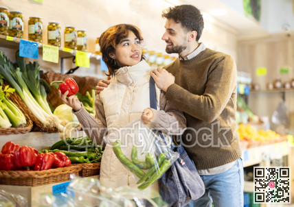 Young couple choosing peppers in store