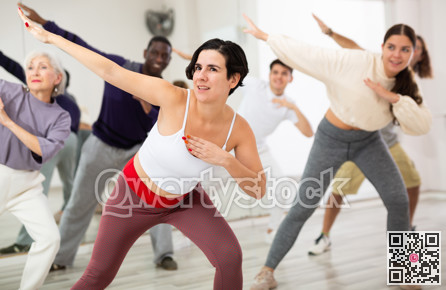 Group of adult people practices dance aerobics