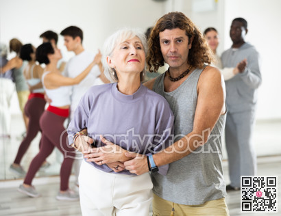 Positive adult man and smiling aged woman dancing in pair