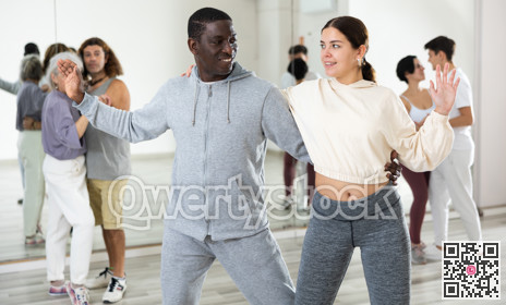 Cheerful girl and man enjoying active dancing in pair