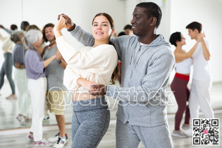 African man and caucasian lady rehearsing latin paired dance moves