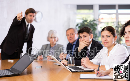 Upset young girl sitting with colleagues scolded by angry boss
