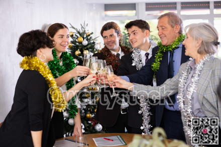 Cheerful colleagues enjoying New Year corporate party in office