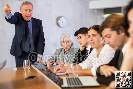 Angry male boss reprehending colleagues on meeting in office