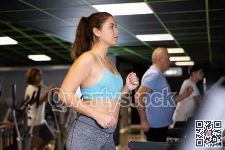 Woman riding cardiovascular trainers in gym