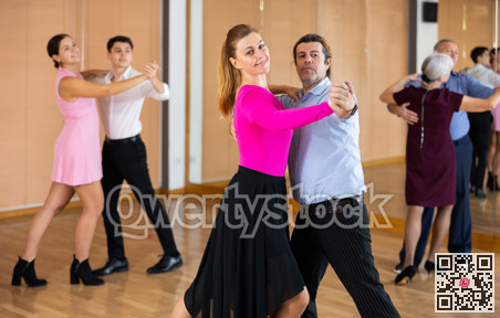 Woman learning to dance Vienneze waltz with partner in dancing class