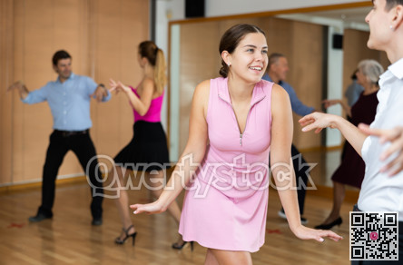 Couple of young dancers rehearsing ballroom dances in dance studio