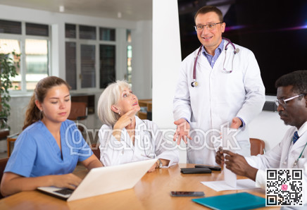 Male doctor speaks at meeting of colleagues and tells reports on condition of patients.