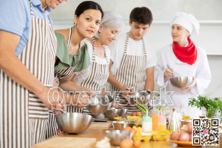 Cooking class - happy friends cooking and talking in kitchen