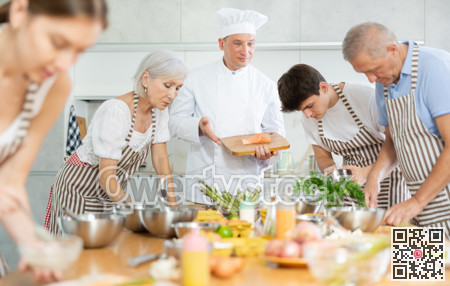 Professional personal chef cook in customer private kitchen house giving cooking lesson to people at home
