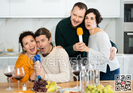 Group of friends are having fun singing karaoke during feast and gatherings.