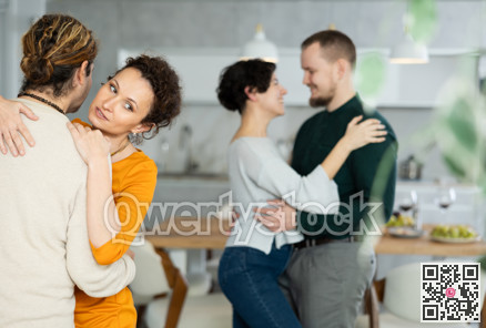 Men and women dancing during house party.