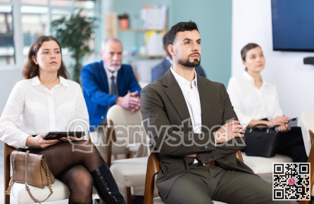 Young man listens to presentation in conference room