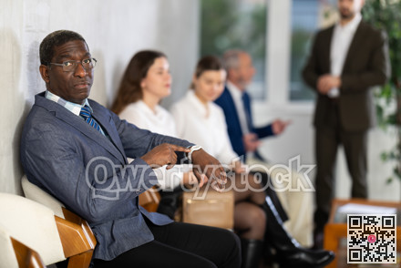 Adult man sitting in job interview queue in office