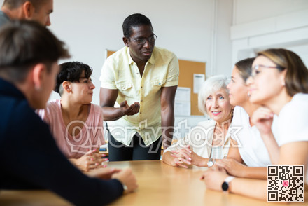 Friendly African American English tutor giving language courses to group of adults