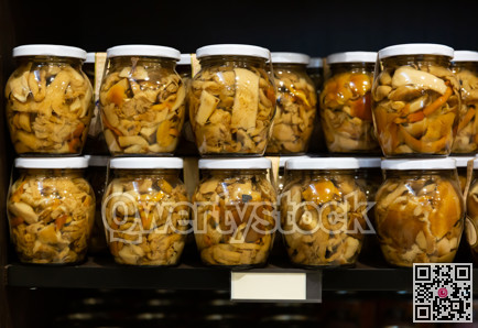 Pickled mushrooms in glass jars in shop