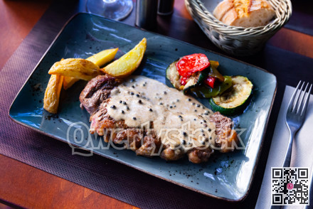Veal steak with piquant creamy sauce, potatoes and vegetables