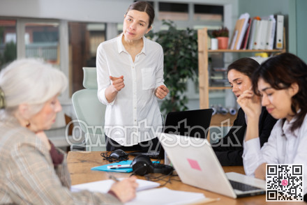 Middle-aged woman standing and scolding colleagues during stressful corporate meeting
